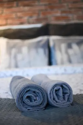 a pair of rolled up towels sitting on a bed at LION apartments - Gold in Kraków