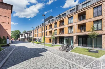 an outdoor balcony with a table and chairs and a building at InPoint Krakow Suites - Steps from Main Station&Old Town Self Check-in in Kraków