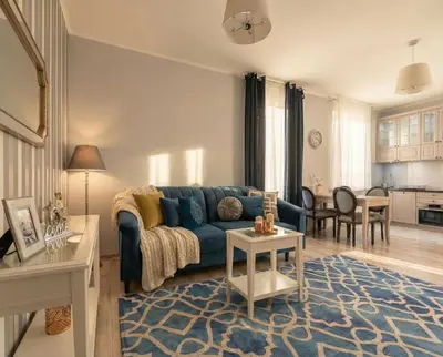 a living room with a blue couch and a table at City Lights Topolowa 8 in Kraków