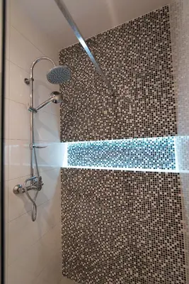 a bathroom with a shower with a mosaic tile wall at City Lights Topolowa 8 in Kraków
