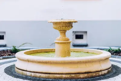 a yellow fountain in the middle of a courtyard at City Lights Topolowa 8 in Kraków