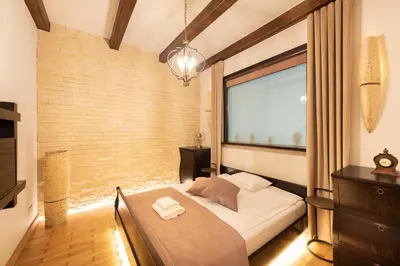a bedroom with a bed and a large window at Krakowhomes in Kraków