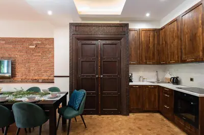a kitchen with wooden cabinets and a table with chairs at Krakowhomes in Kraków