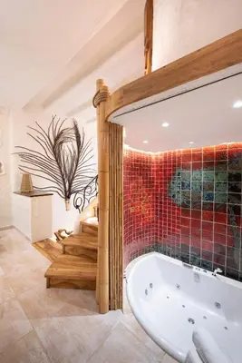 a bathroom with a tub and a mosaic wall at Krakowhomes in Kraków