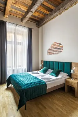 a bedroom with a large bed and a large window at Aparthotel Pergamin in Kraków