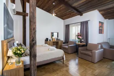 a bedroom with a bed and a living room at Aparthotel Pergamin in Kraków