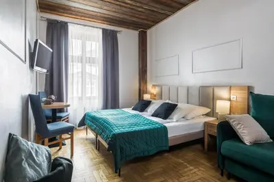 a hotel room with a bed and a green couch at Aparthotel Pergamin in Kraków