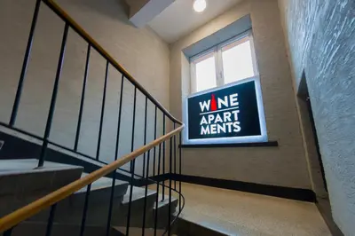 a room with a bed and a tv under a staircase at Wine Apartments in Kraków