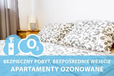 a bedroom with a bed with a pillow and a table at Bronowice in Kraków