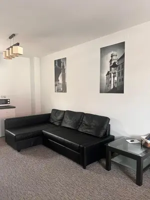 a living room with a black couch and a table at Bronowice in Kraków
