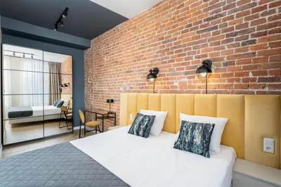 a bedroom with a brick wall and a bed with pillows at 1898 Parkside Boutique Residence in Kraków