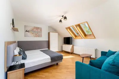 a bedroom with a bed and a blue couch at 1898 Parkside Boutique Residence in Kraków