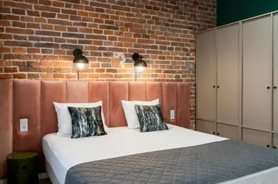 a bedroom with a bed with a brick wall at 1898 Parkside Boutique Residence in Kraków