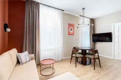 a living room with a table and a couch at 1898 Parkside Boutique Residence in Kraków