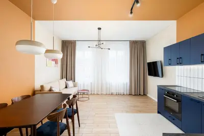 a kitchen and living room with a table and chairs at 1898 Parkside Boutique Residence in Kraków