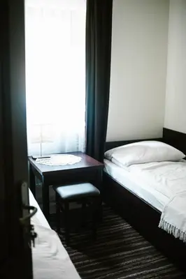 a bedroom with two beds and a desk and a window at Willa Zacisze - Apartament dwupoziomowy in Kalwaria Zebrzydowska