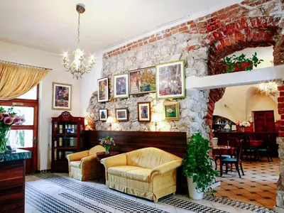 a living room with a stone wall with a fireplace at Miodosytnia Aparthotel in Kraków