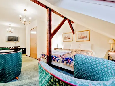 a bedroom with a bed and two chairs at Miodosytnia Aparthotel in Kraków