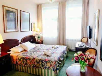 a hotel room with a bed and a table with flowers on it at Miodosytnia Aparthotel in Kraków