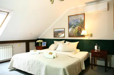 a bedroom with two beds and a painting on the wall at Miodosytnia Aparthotel in Kraków
