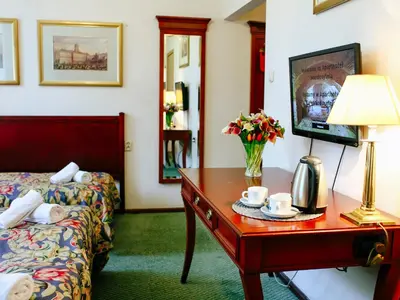 a hotel room with a bed and a table with a lamp at Miodosytnia Aparthotel in Kraków