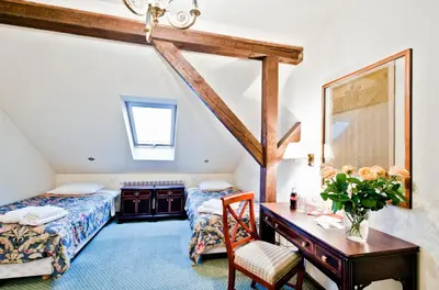 a bedroom with two beds and a desk with a table at Miodosytnia Aparthotel in Kraków