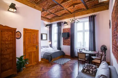 a bedroom with a bed and a table in a room at Lovenovsky Apartments in Kraków
