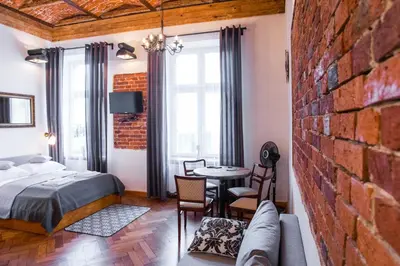 a bedroom with a bed and a brick wall at Lovenovsky Apartments in Kraków