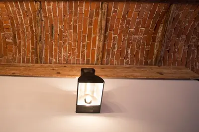 a light in a room with a wooden wall at Lovenovsky Apartments in Kraków