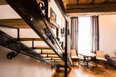 a living room with a staircase and a table at Lovenovsky Apartments in Kraków