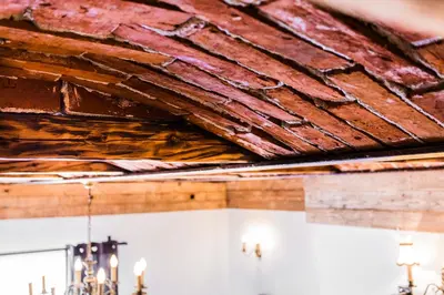 a damaged ceiling in a room with a brick wall at Lovenovsky Apartments in Kraków
