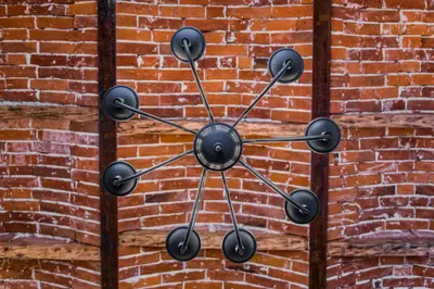 a metal cross hanging on a brick wall at Lovenovsky Apartments in Kraków