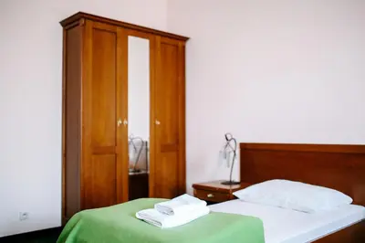 a bedroom with two beds and a wooden cabinet at Pałac Koronny Noclegi & Wypoczynek in Wodzisław