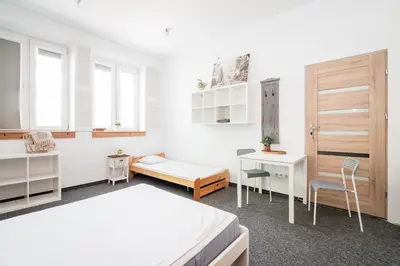 a white room with two beds and a desk at Master Corner Apartment in Kraków