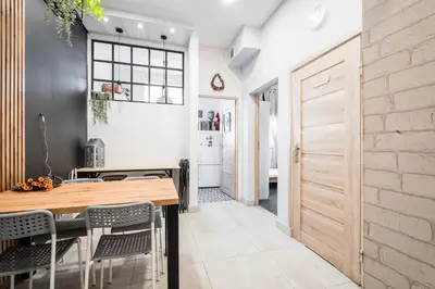 a kitchen with a wooden table and chairs at Master Corner Apartment in Kraków