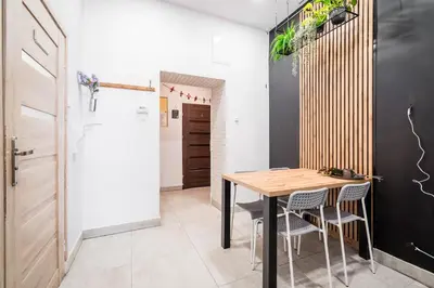 a dining room with a wooden table and chairs at Master Corner Apartment in Kraków