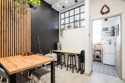 a kitchen with two tables and a refrigerator at Master Corner Apartment in Kraków