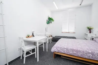 a bedroom with a bed and a table and chairs at Master Corner Apartment in Kraków