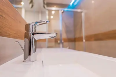 a bathroom sink with a chrome faucet on a counter at BAKO Apartments in Skawina