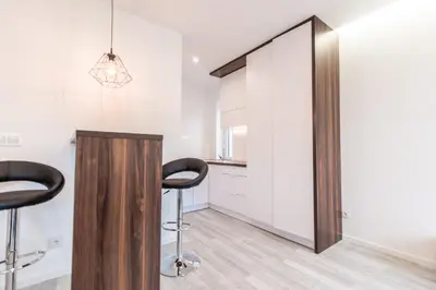 a kitchen with two bar stools and a mirror at BAKO Apartments in Skawina