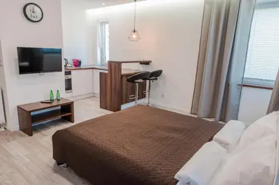 a bedroom with a bed and a desk and a television at BAKO Apartments in Skawina
