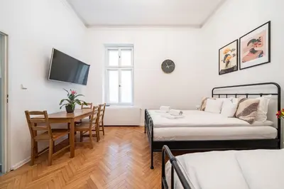 a bedroom with a bed and a table and a tv at Kazimierz Pearl Apartments in Kraków