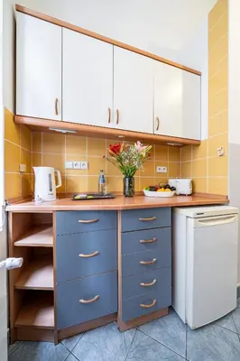 a kitchen with blue and white cabinets and a sink at Kazimierz Pearl Apartments in Kraków