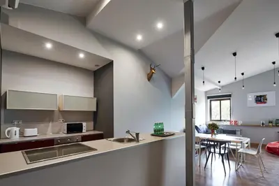 a kitchen with a sink and a table with chairs at PlayHouse Apartments in Kraków
