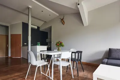 a dining room and kitchen with a table and chairs at PlayHouse Apartments in Kraków