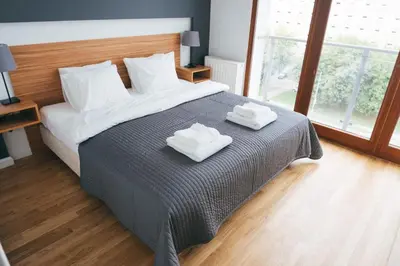 a bedroom with a bed with two towels on it at Grey Apartment Kołowa in Kraków