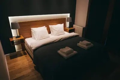 a bedroom with a large bed with two towels on it at Grey Apartment Kołowa in Kraków