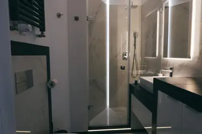 a bathroom with a shower and a sink at Grey Apartment Kołowa in Kraków