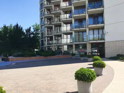 a large apartment building with potted plants in front of it at Grey Apartment Kołowa in Kraków