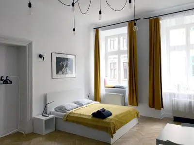 a bedroom with a bed and a large window at Florianska Apartment in Kraków